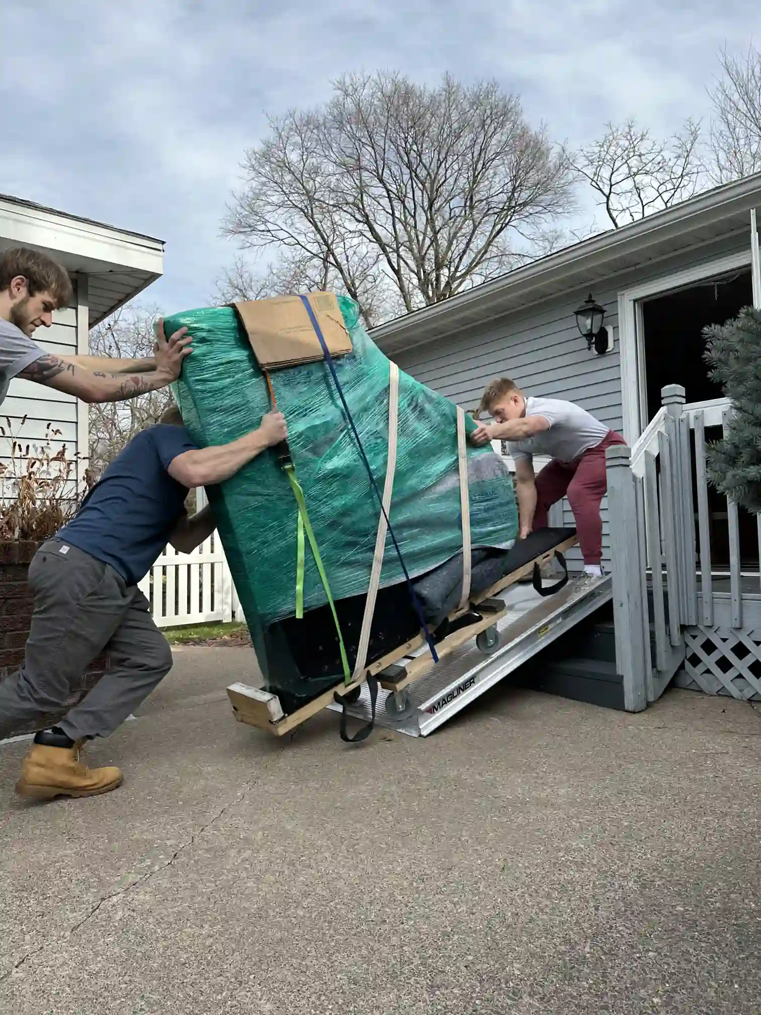 Movers carefully carrying a baby grand piano down stairs