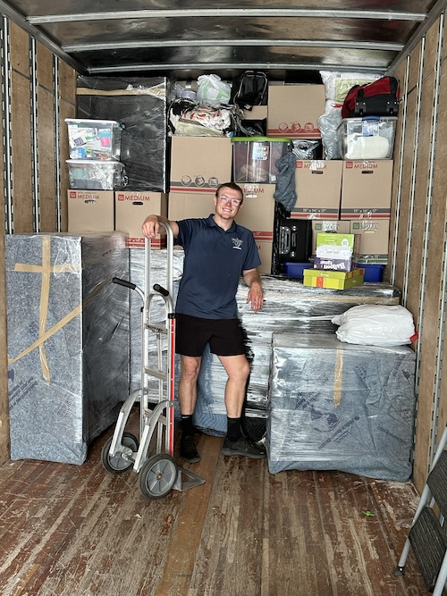 An Elite Movers crew member carrying furniture